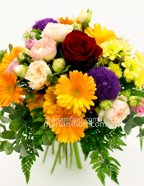 Bouquet creato dal fiorista con una rosa rossa e verdi decorativi